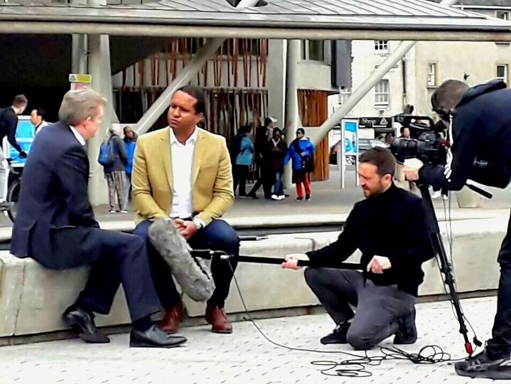 Louis Stedman-Bryce being interviewed on camera outside the Scottish Parliament